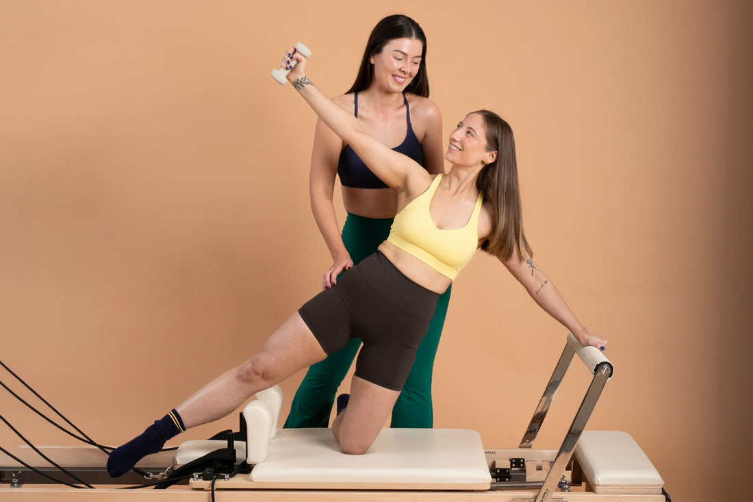 Reformer instructor helping a client