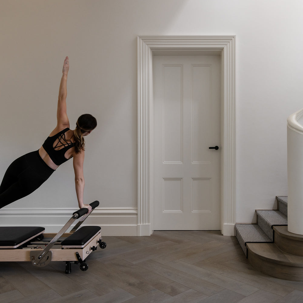 Women doing reformer pilates at home